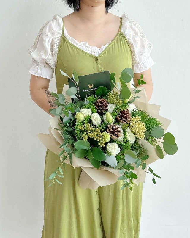 Flowers and kisses forest ranch flower arrangement using lisianthus, wild leaves and pine to emulate a crisp forest during christmas