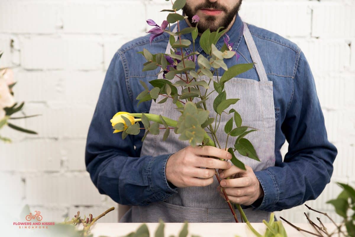 How To Arrange Flowers In A Vase A Florist Adding a Greenery