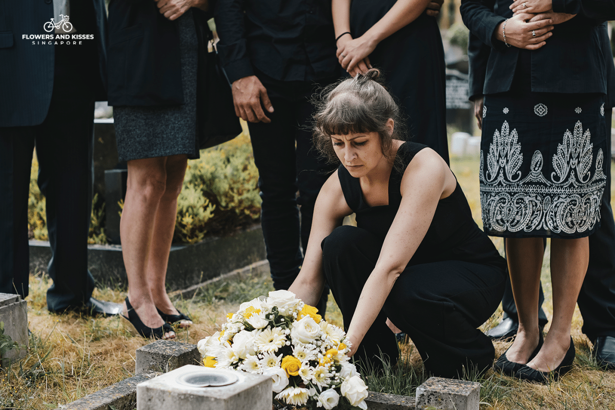 5 Reasons To Send Your Loved One A Bouquet Of Flowers Today A Woman Placing a Condolence Flower