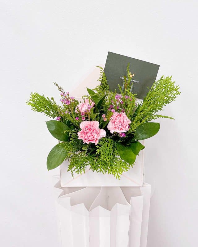 A bouquet of pink carnations and other flowers designed by Flowers and Kisses