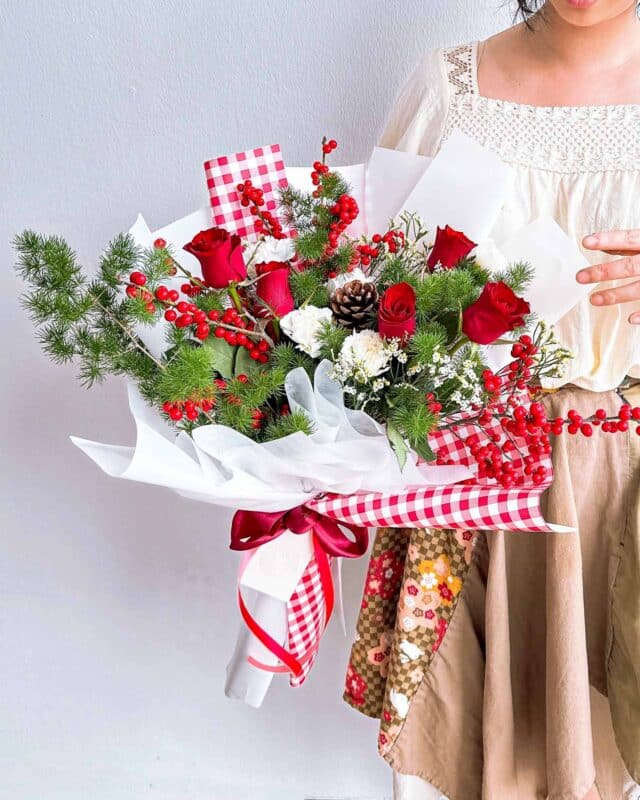 Flowers and kisses carol flower arrangement featuring a classic christmas pairing of red roses and white flowers